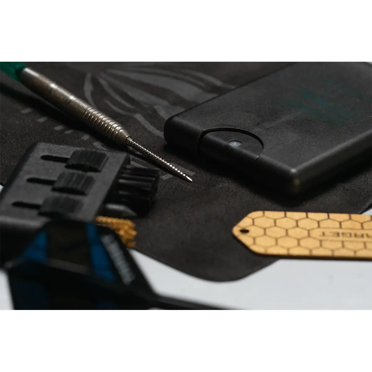 Target Dart Servicing Kit in Anwendung mit Bürstenmodul, Schärfer und Dartbarrel auf Reinigungstuch